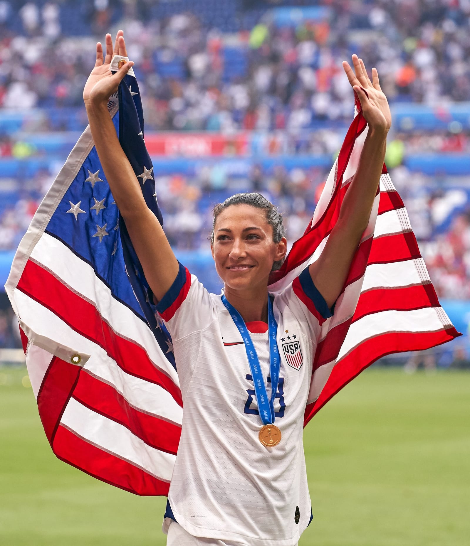 Christen Press holding the American flag after a World Cup win